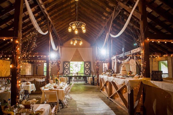 Couple walking through cheering guests in the RED House barn