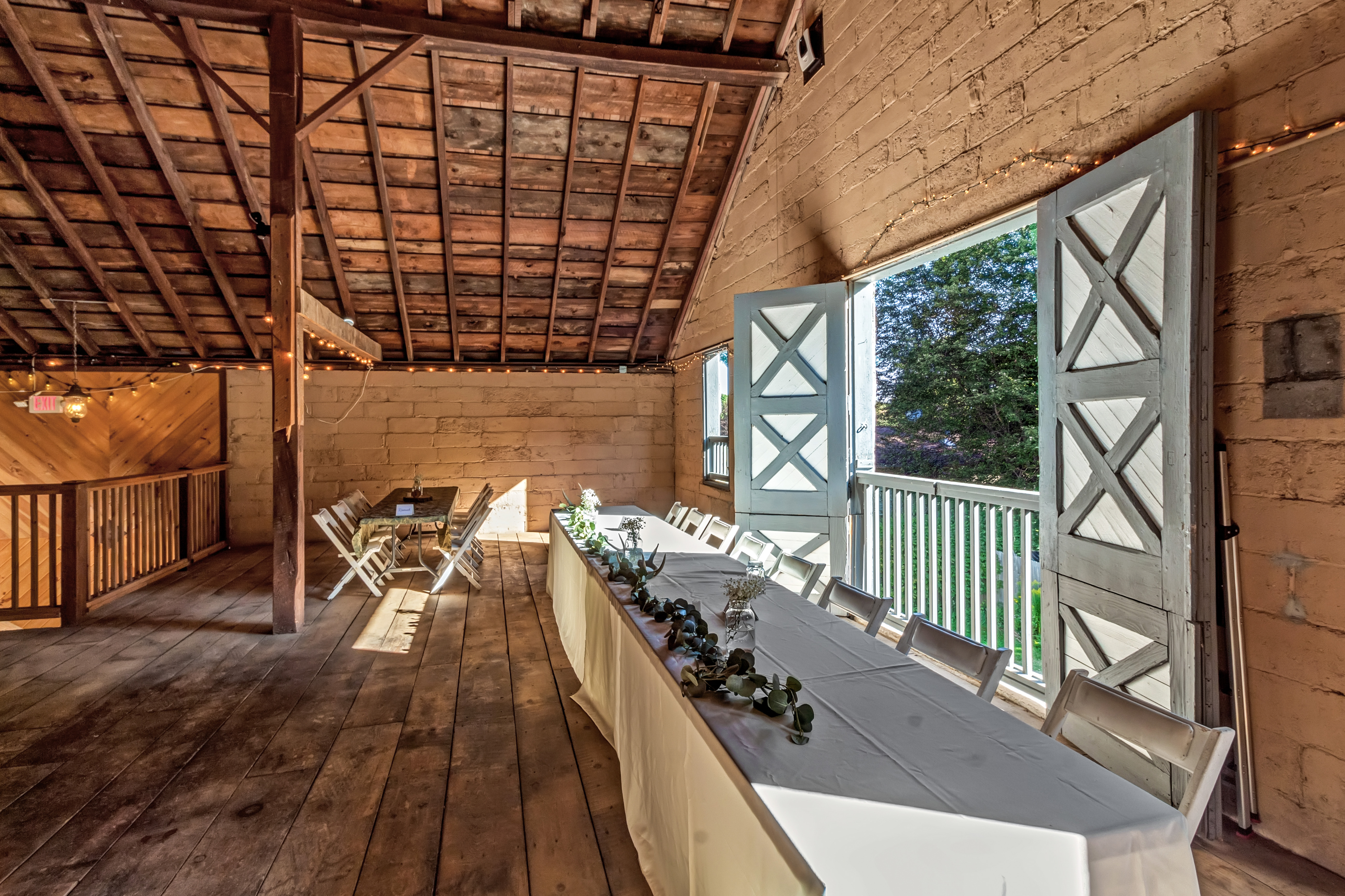 The RED House barn interior with open dutch doors framing the trees beyond