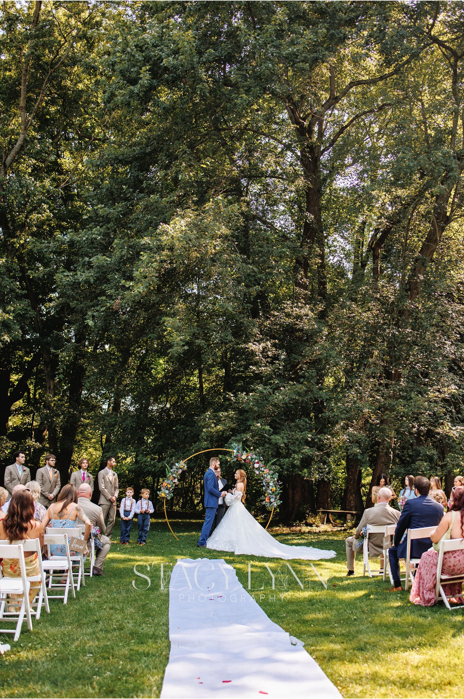 Outdoor wedding ceremony on the RED House grounds under a canopy of trees